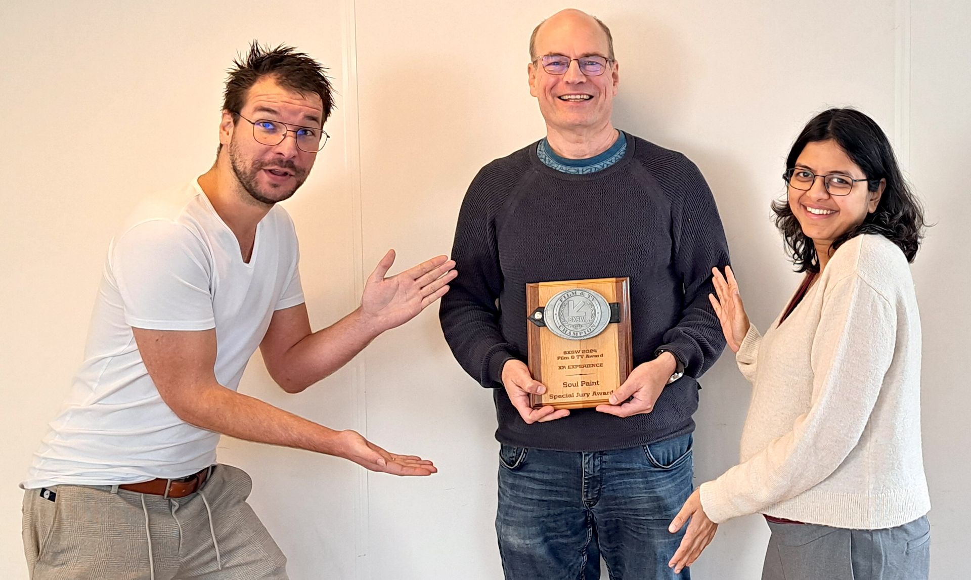 Roger ter Heide holding the SxSW Award, with Richard van de Lagemaat and Nikita Kayal standing next to him.